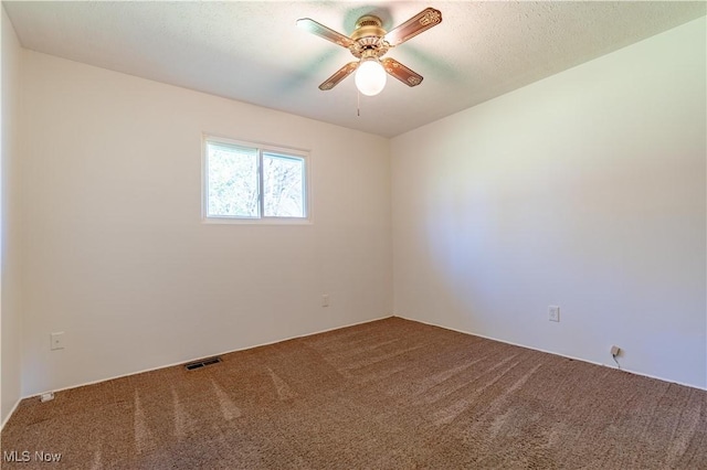 carpeted empty room with visible vents and ceiling fan