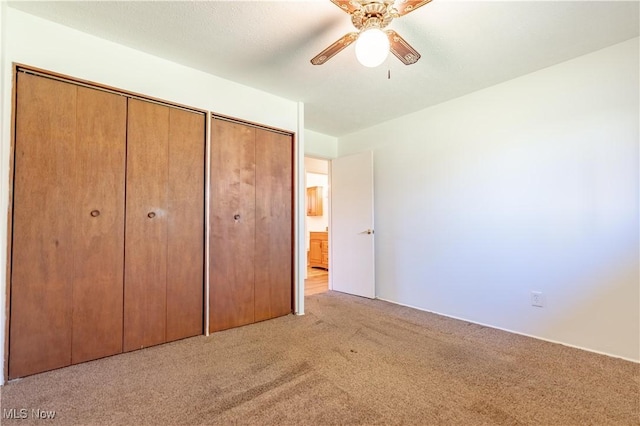 unfurnished bedroom featuring a closet, a ceiling fan, and carpet flooring