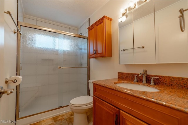 bathroom with vanity, a stall shower, and toilet