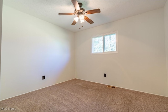 empty room with ceiling fan, carpet flooring, and visible vents