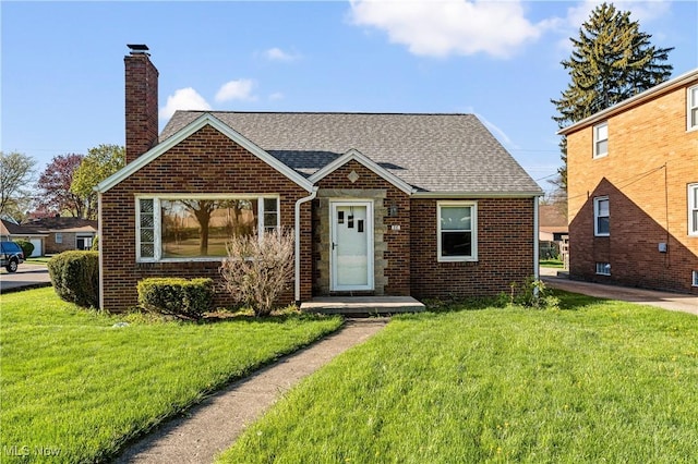 view of front of house with brick siding, a chimney, and a front yard
