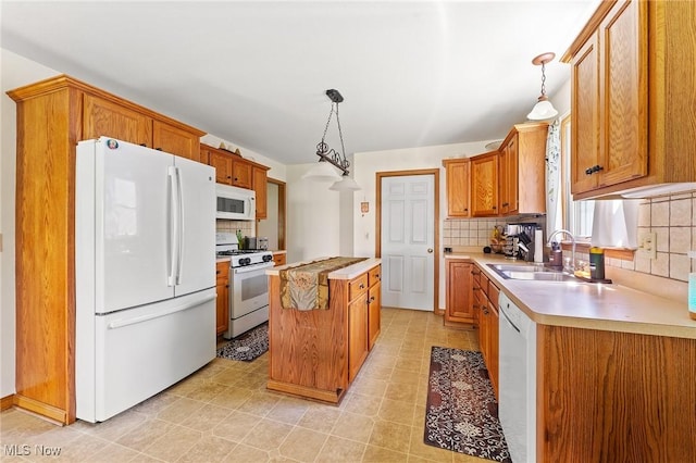 409 Pin Oak Pl, Campbell, OH 44405 - kitchen featuring white appliances, a center island, light countertops, a sink, and backsplash