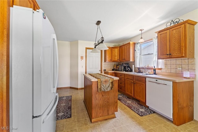 409 Pin Oak Pl, Campbell, OH 44405 - kitchen with a sink, white appliances, light countertops, a center island, and tasteful backsplash