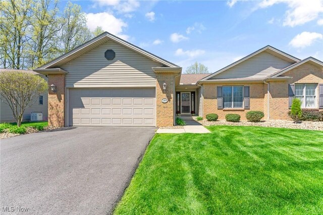409 Pin Oak Pl, Campbell, OH 44405 - single story home with aphalt driveway, central AC, a front yard, brick siding, and an attached garage