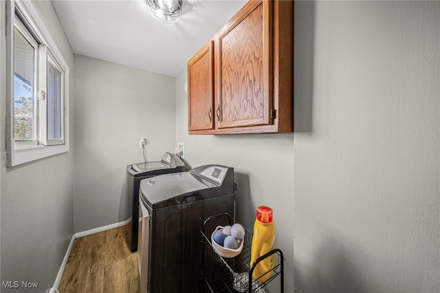 6084 Clay St, Thompson, OH 44086 - washroom featuring separate washer and dryer, baseboards, cabinet space, and wood finished floors