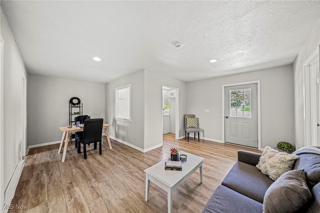 6084 Clay St, Thompson, OH 44086 - living area with light wood finished floors, a textured ceiling, recessed lighting, baseboards, and a baseboard radiator