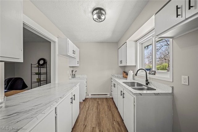 6084 Clay St, Thompson, OH 44086 - kitchen with a textured ceiling, dark wood finished floors, a sink, white cabinets, and a baseboard heating unit