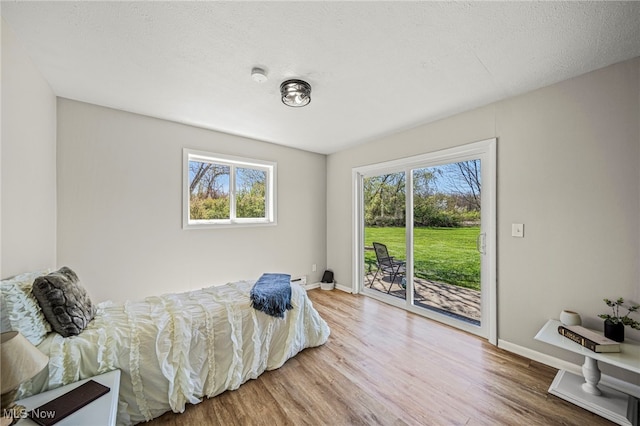 6084 Clay St, Thompson, OH 44086 - bedroom with baseboards, access to outside, and wood finished floors