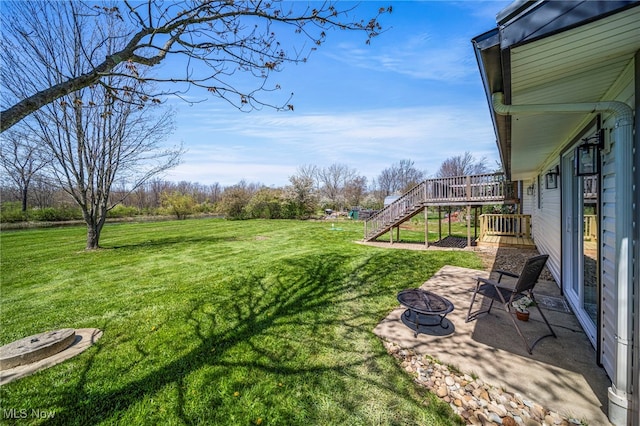 6084 Clay St, Thompson, OH 44086 - view of yard featuring an outdoor fire pit, a patio area, stairway, and a deck