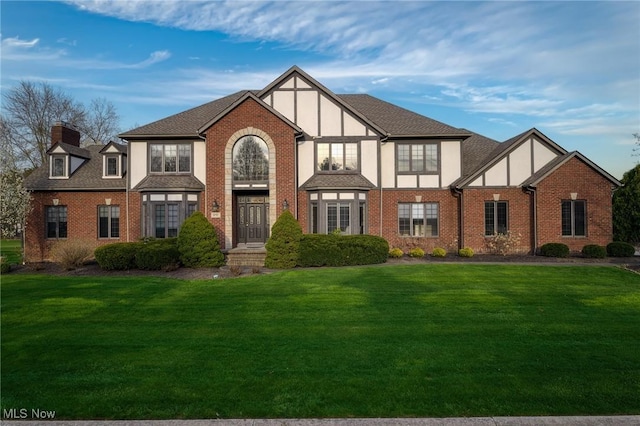 275 Camden Ln, Aurora, OH 44202 - tudor home with a front lawn and brick siding