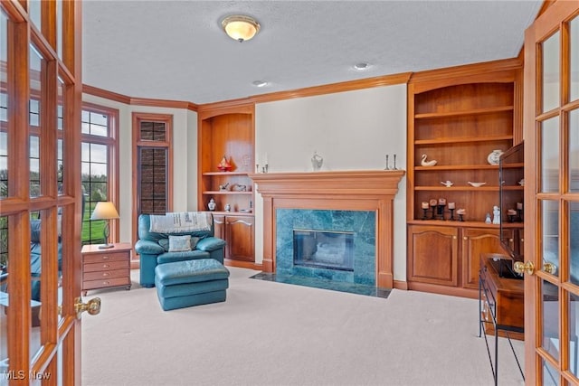 275 Camden Ln, Aurora, OH 44202 - carpeted living area with crown molding, a premium fireplace, a textured ceiling, built in features, and french doors