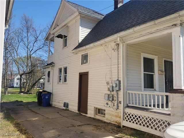 9615 Dunlap Ave, Cleveland, OH 44105 - view of home's exterior with covered porch, a chimney, and roof with shingles
