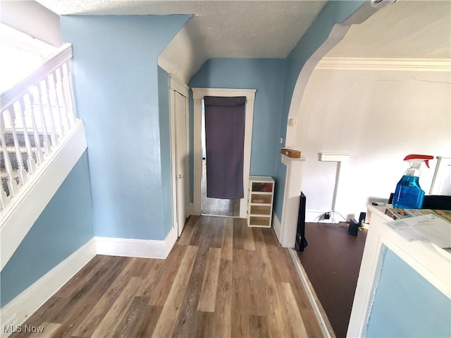 9615 Dunlap Ave, Cleveland, OH 44105 - hall with baseboards, arched walkways, wood finished floors, and stairway