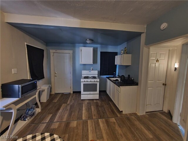 9615 Dunlap Ave, Cleveland, OH 44105 - kitchen with white cabinets, stainless steel microwave, dark wood finished floors, and gas range gas stove