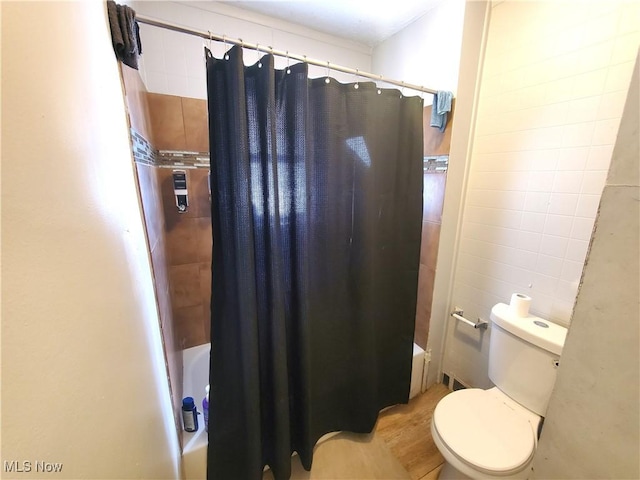 9615 Dunlap Ave, Cleveland, OH 44105 - bathroom featuring toilet, tile walls, wood finished floors, and shower / bath combo
