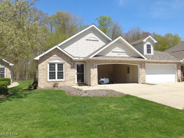 view of front of property with a garage, a front lawn, and driveway