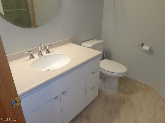 bathroom featuring toilet, tile patterned floors, and vanity