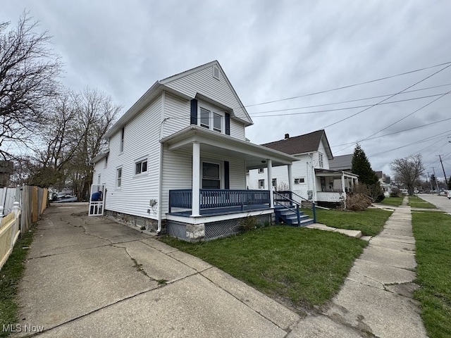 view of front of home featuring fence, a porch, and a front yard