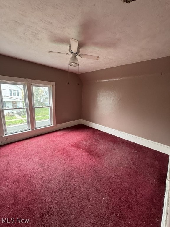 carpeted empty room featuring a ceiling fan, baseboards, and a textured ceiling
