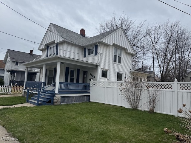 view of front of house featuring fence, a chimney, a porch, and a front yard