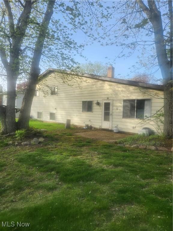 6876 Anthony Ln, Parma Heights, OH 44130 - rear view of house featuring a lawn and a chimney
