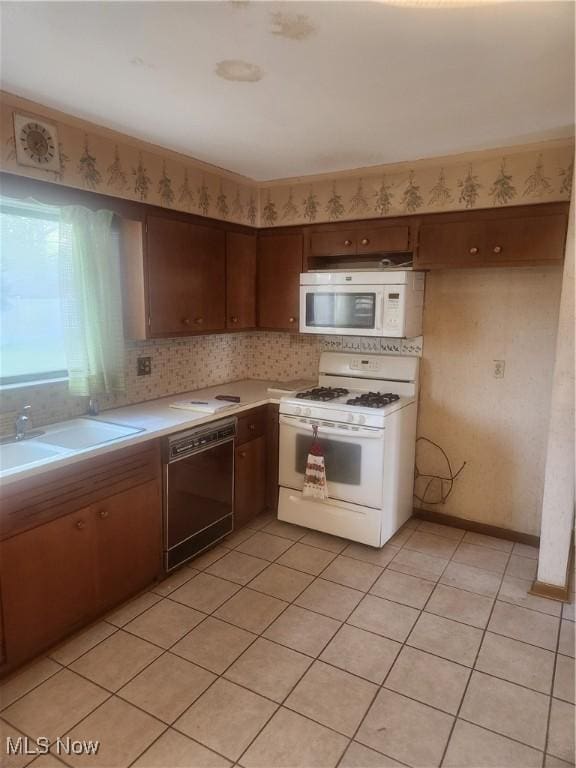 6876 Anthony Ln, Parma Heights, OH 44130 - kitchen with white appliances, light countertops, a sink, backsplash, and light tile patterned floors