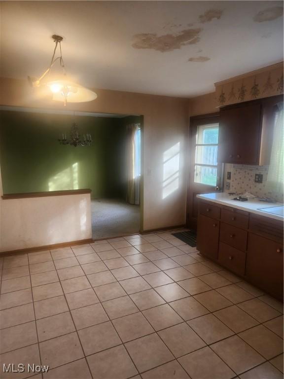6876 Anthony Ln, Parma Heights, OH 44130 - kitchen featuring light countertops, light tile patterned flooring, decorative light fixtures, and decorative backsplash