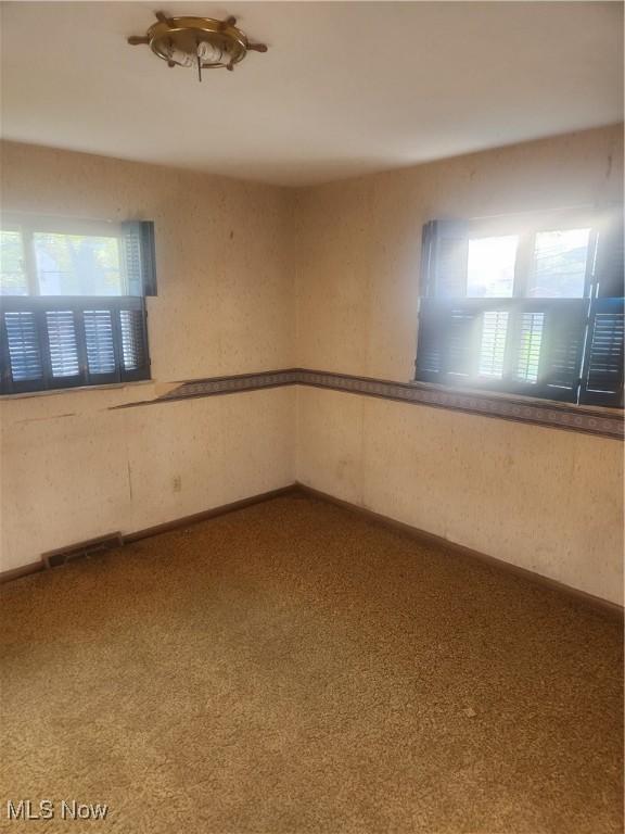 6876 Anthony Ln, Parma Heights, OH 44130 - empty room featuring carpet floors, visible vents, and a wealth of natural light