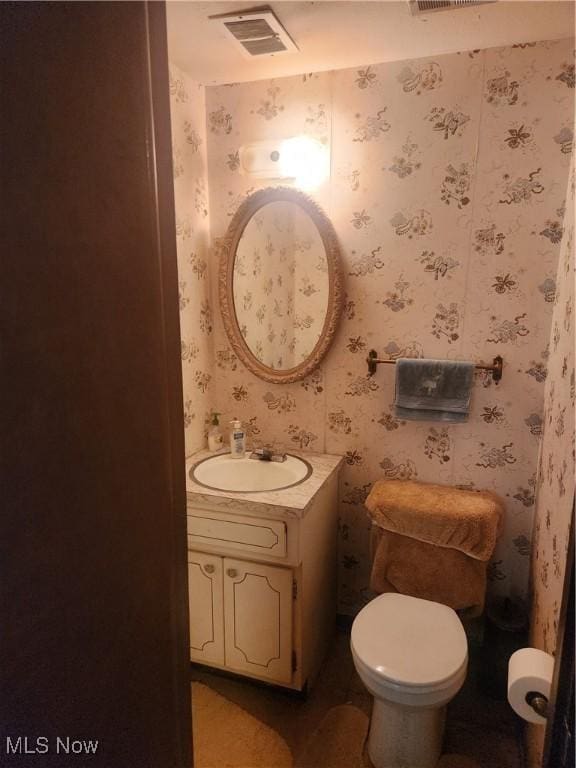 6876 Anthony Ln, Parma Heights, OH 44130 - bathroom featuring toilet, wallpapered walls, visible vents, and vanity