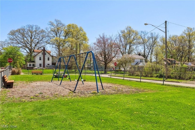 community play area with fence and a yard