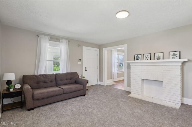 carpeted living area with baseboards and a fireplace