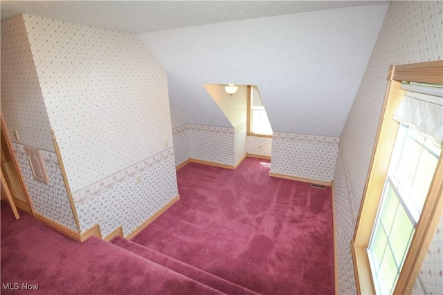 bonus room with carpet floors, baseboards, wallpapered walls, and lofted ceiling