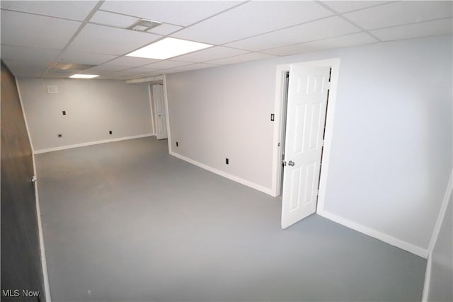 finished below grade area with baseboards, visible vents, and a paneled ceiling