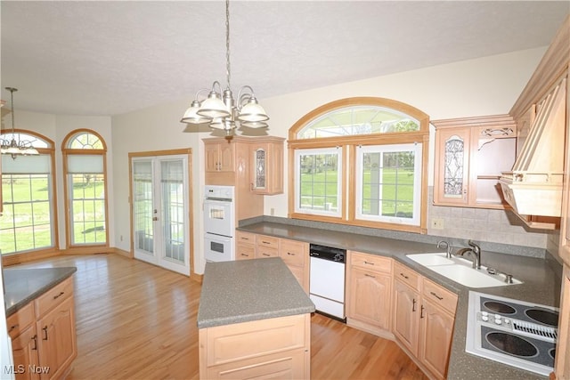 kitchen featuring light brown cabinets, white appliances, light wood-style floors, a sink, and a notable chandelier