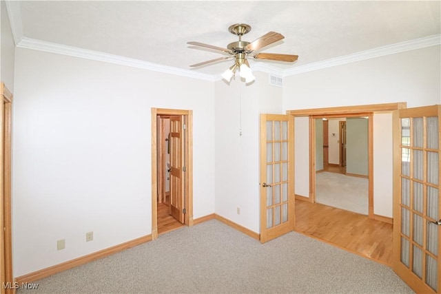 spare room with crown molding, ceiling fan, french doors, and visible vents