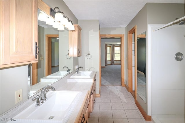 bathroom featuring double vanity, a sink, and tile patterned flooring