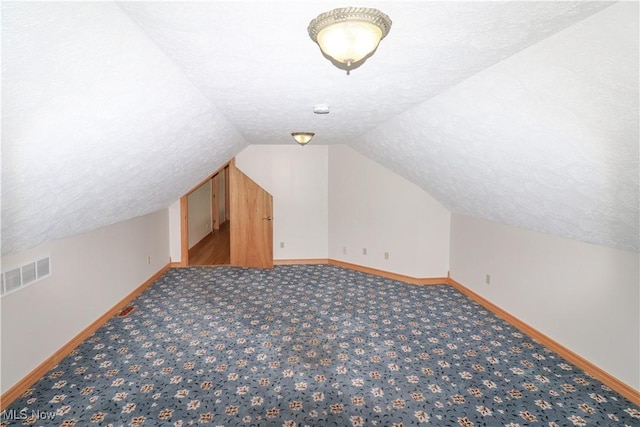 bonus room with carpet floors, baseboards, lofted ceiling, and visible vents