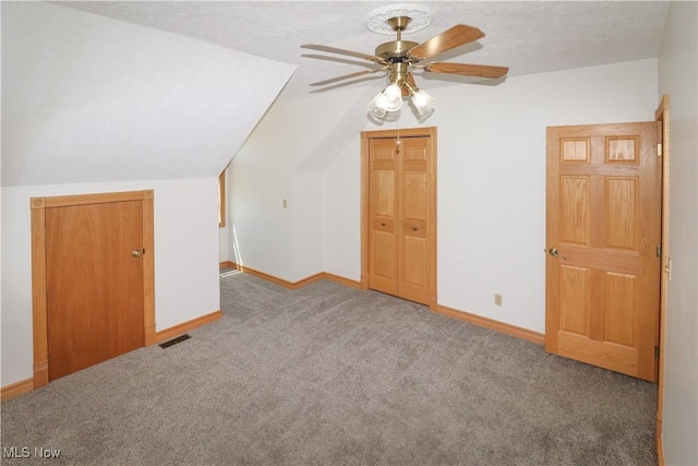 additional living space featuring carpet flooring, ceiling fan, baseboards, lofted ceiling, and visible vents