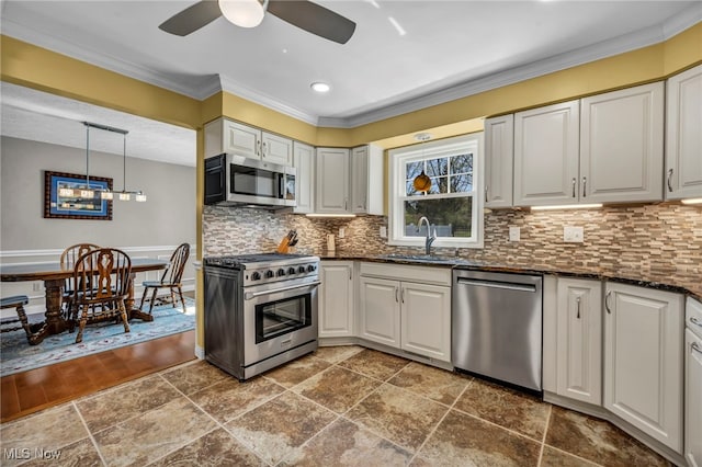 kitchen featuring crown molding, decorative backsplash, ceiling fan, a sink, and stainless steel appliances