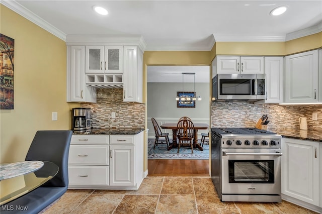 kitchen featuring decorative backsplash, dark stone counters, ornamental molding, stainless steel appliances, and white cabinetry
