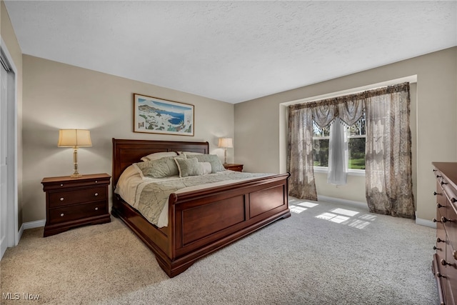 bedroom featuring baseboards, light carpet, and a closet