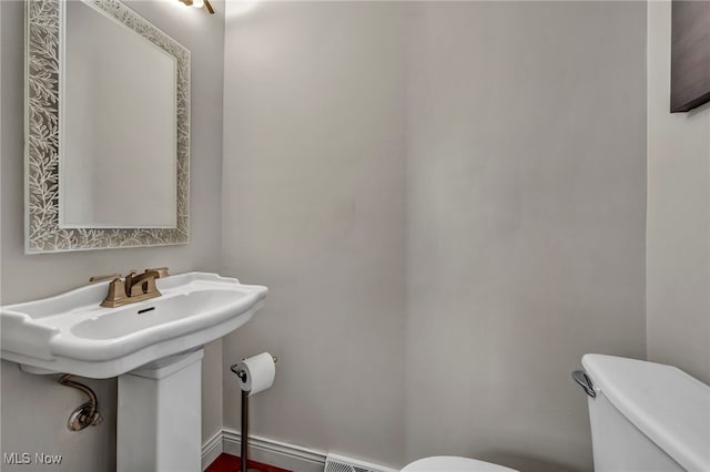 half bathroom featuring visible vents and toilet