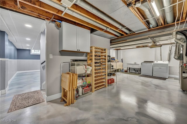 below grade area featuring recessed lighting, a sink, baseboards, and washing machine and dryer