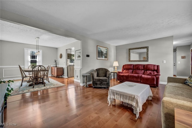 living room featuring a textured ceiling and wood finished floors