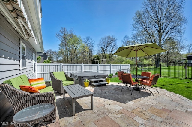 view of patio / terrace with a hot tub, a fenced backyard, and outdoor dining space