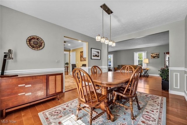 dining room with a textured ceiling and wood finished floors