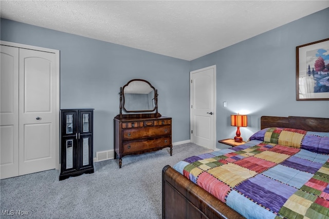 bedroom with carpet flooring, a textured ceiling, baseboards, and visible vents