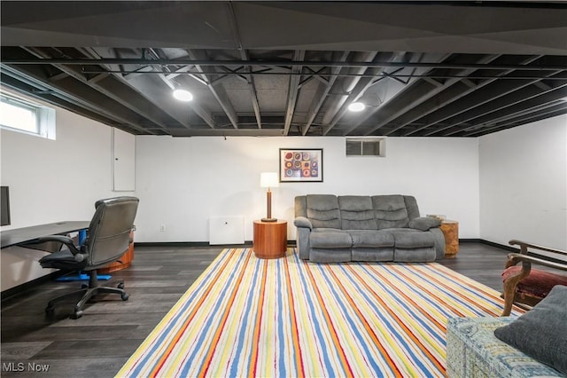 living area with baseboards, visible vents, and wood finished floors