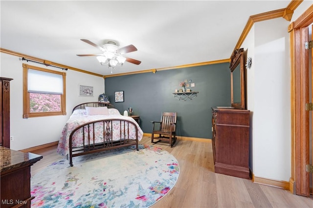 bedroom with crown molding, baseboards, and light wood finished floors