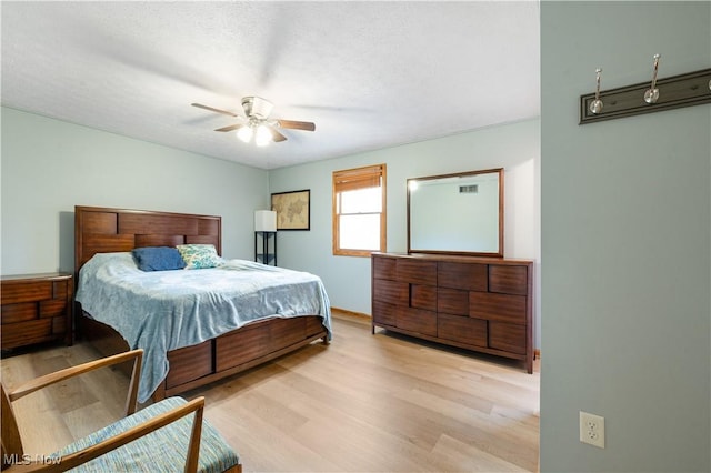 bedroom featuring baseboards, a ceiling fan, and wood finished floors